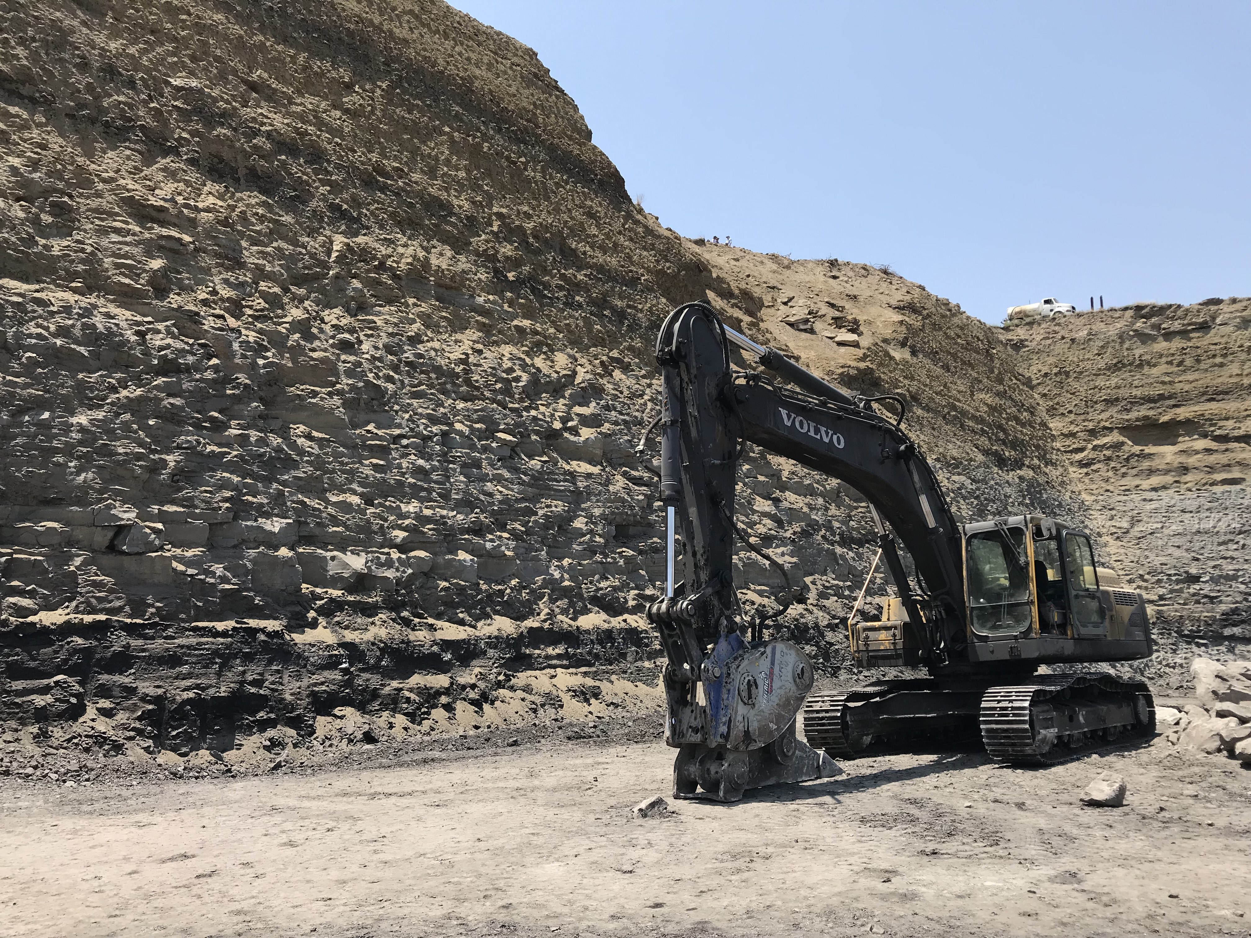 Excavadora Volvo con martillo rompedor en frente de carbón