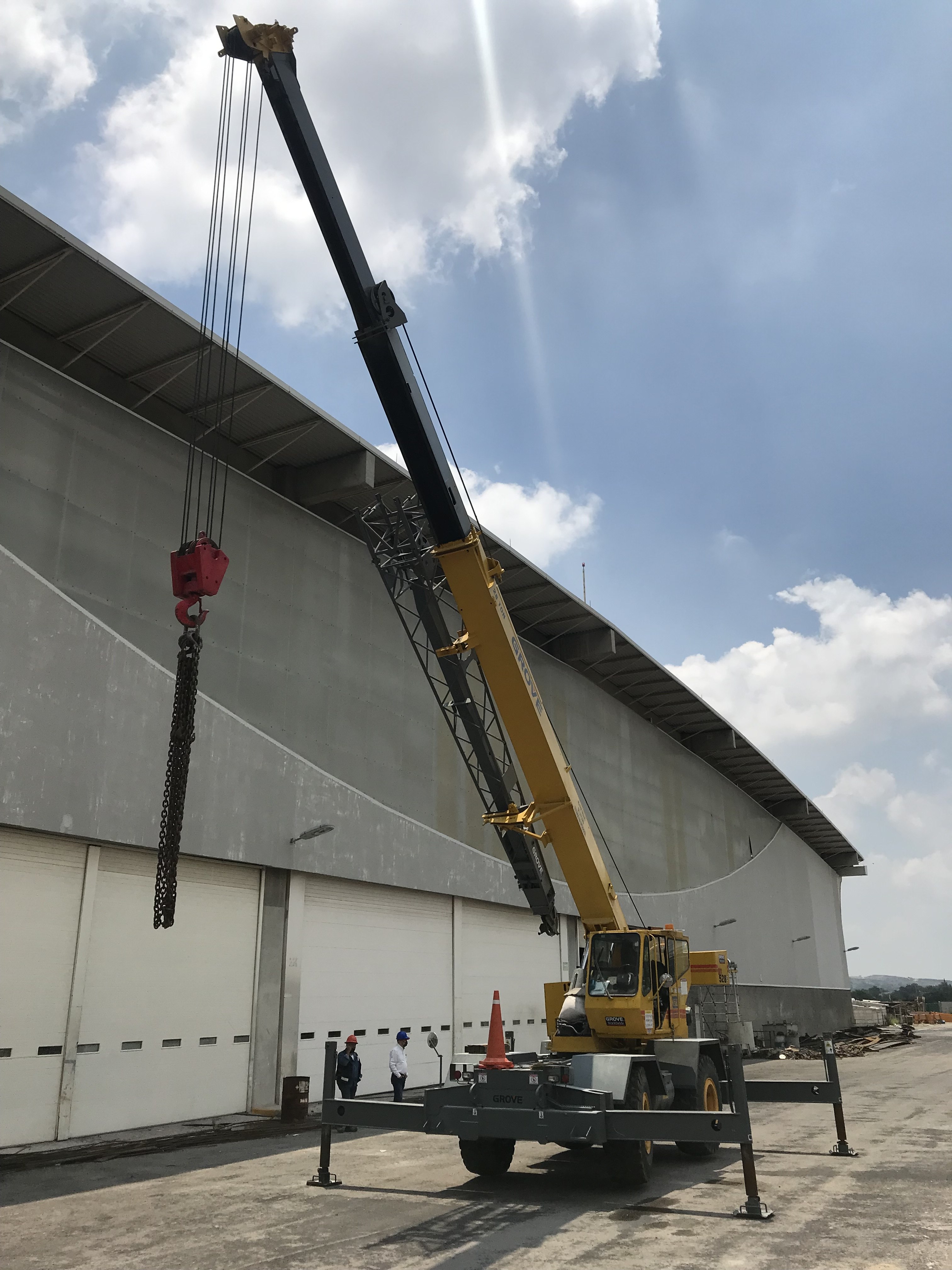 Grúa Grove RT en maniobra junto a nave industrial
