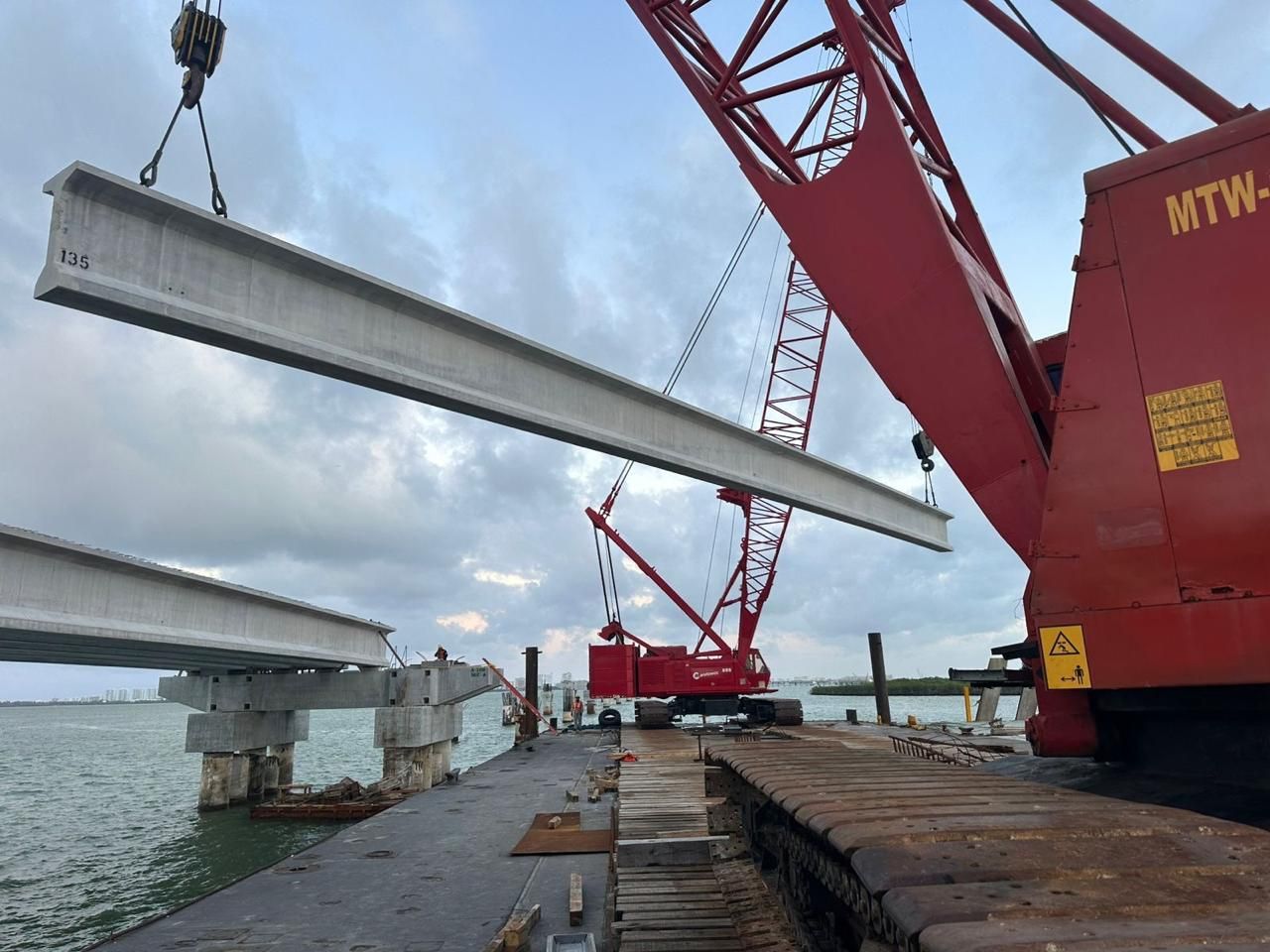 Grúa Manitowoc 888 de Grupo GTC izando trabe sobre laguna en el Puente Nichupté